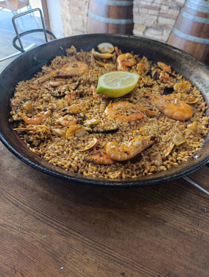 Paella de marisco recién hecha en su paellera, con gambas, cigalas y mejillones